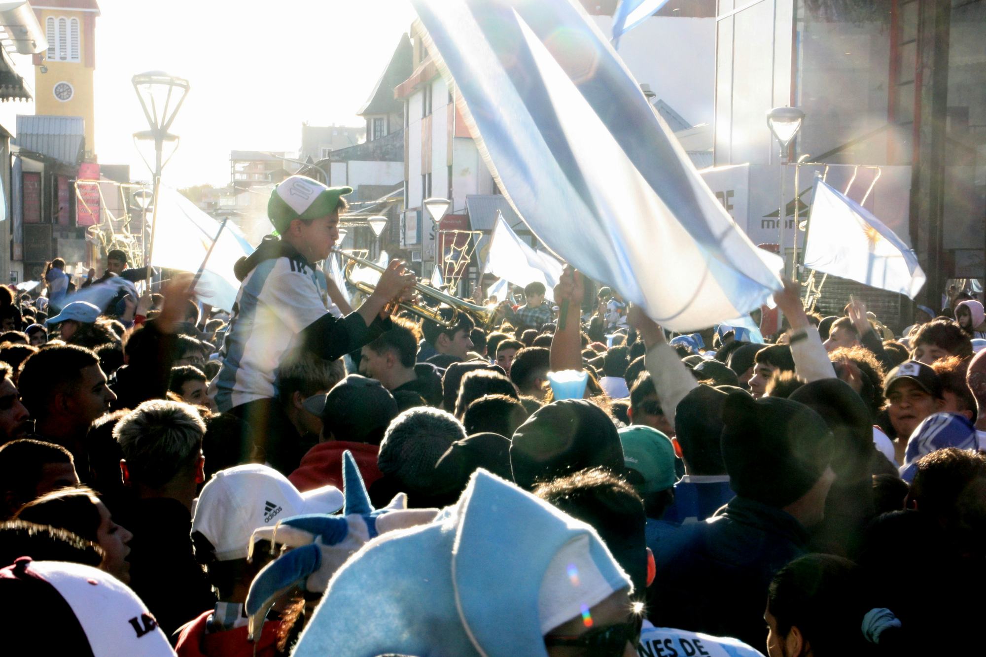 Supporters waving large flags in a crowded street