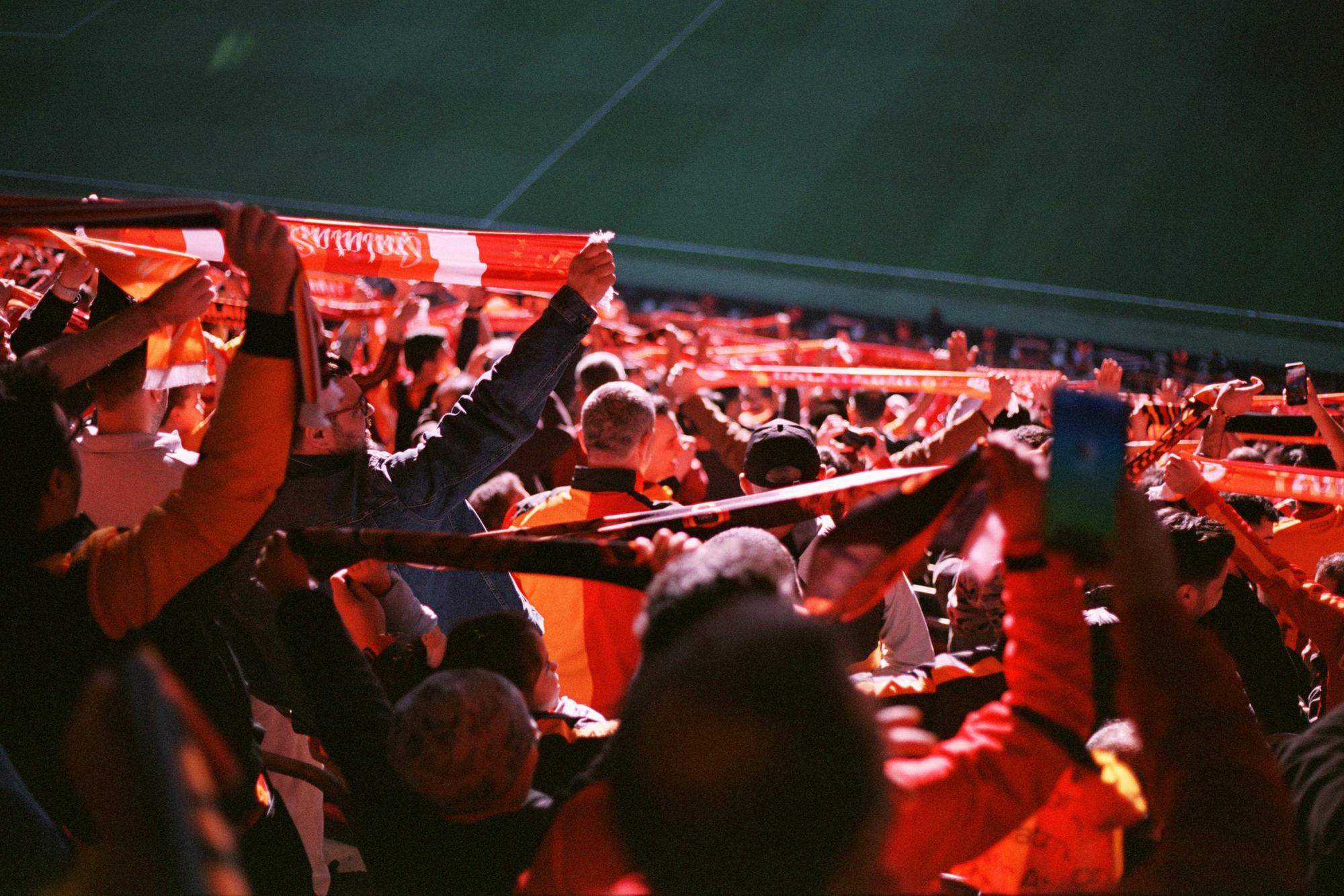 Supporters in a stand holding scarves above their heads
